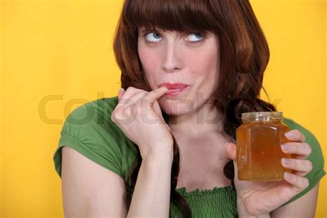 Woman Tasting Honey From The Jar Stock Image Colourbox