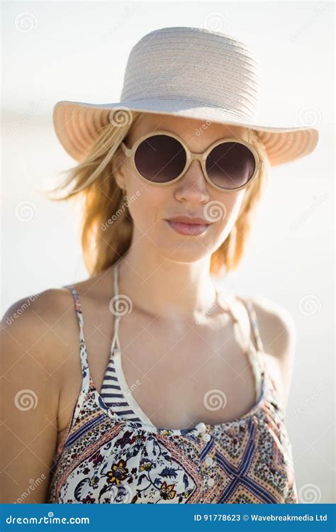 Portrait Of Young Woman Wearing Sunglasses And Hat At Beach Stock Image