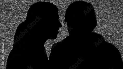 A Woman Whispering A Secret In The Ear Of A Man Silhouette Shot Over