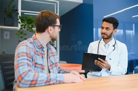 Medicine Healthcare And People Concept Indian Doctor Giving Prescription To Male Patient At