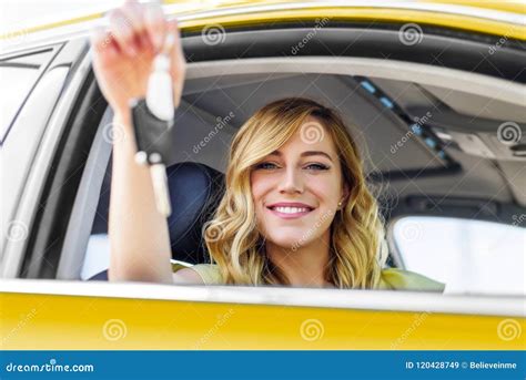 An Attractive Woman In The Yellow Car Holds A Car Key In Her Hand