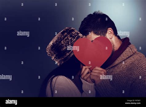 Young Couple Kissing Behind Red Heart Stock Photo Alamy