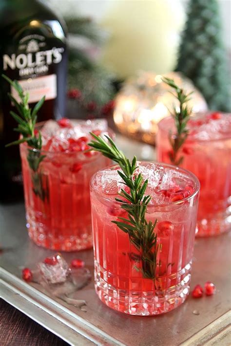 Three Glasses Filled With Red Liquid And Garnished With Rosemary Sprigs
