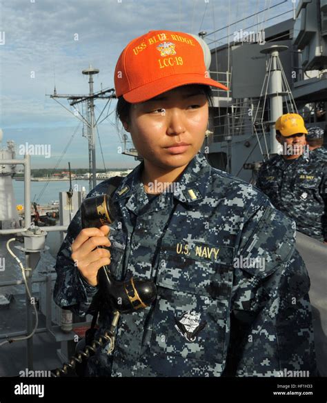 ensign amy kim officer of the deck monitors the pier from 7th fleet command flagship uss blue