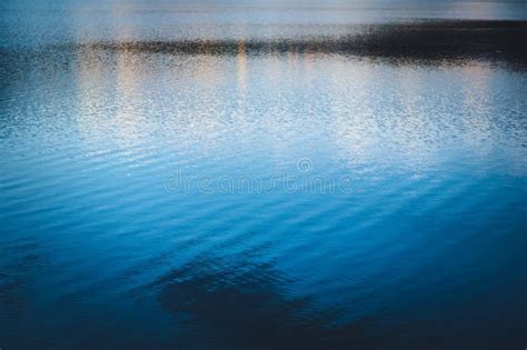 Intense Blue Twilight Sky Reflected Over The Waters Of A Lake Stock