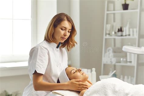 Woman Cosmetologist Making Face Massage For Woman Client In Beauty Spa