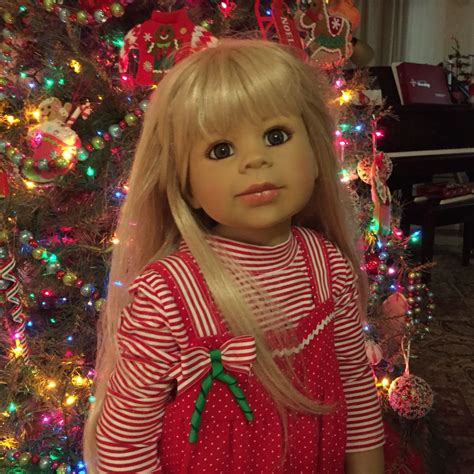 A Doll Is Standing In Front Of A Christmas Tree