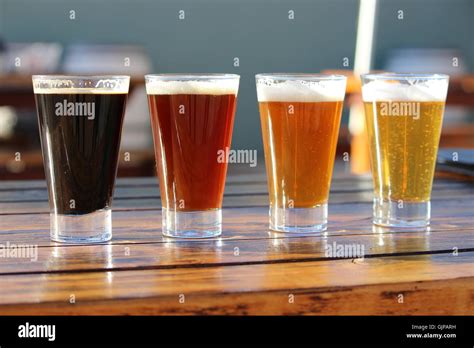 A Selection Of Four Craft Beers During A Tasting Session On A Wooden