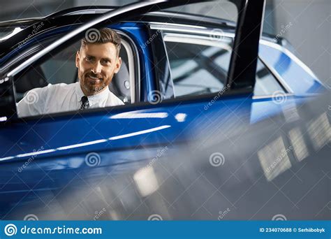 Handsome Businessman Buying New Car At Auto Showroom Stock Photo