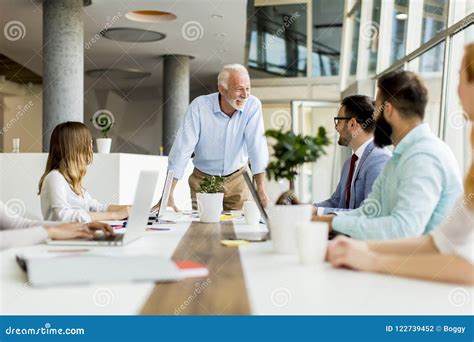 Senior Boss Holds A Meeting For Younger Colleagues Stock Photo Image