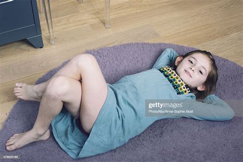 Girl Lying On Floor With Hands Behind Head Smiling Bildbanksbilder
