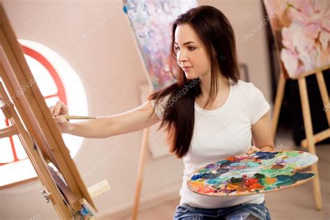 Female Artist Working On Painting In Studio — Stock Photo © Bezzznika