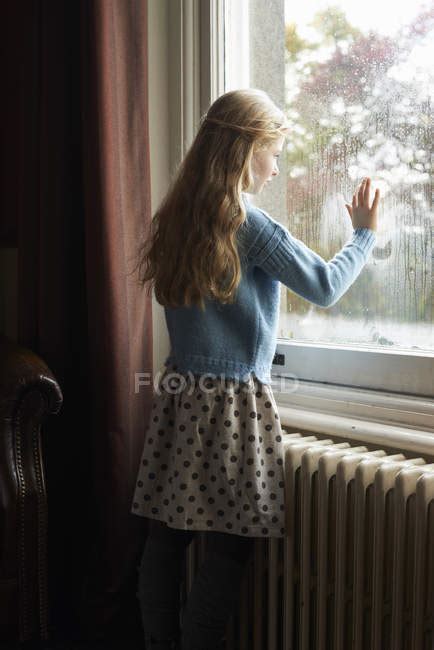 Back View Of Girl Looking Out Window — Childhood Elementary Age