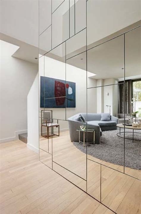 A Living Room Filled With Furniture Next To A Large Mirror On Top Of A Wall