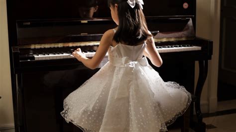 Tu Rear View Girl In White Dress Playing Piano Turns And Smile Stock