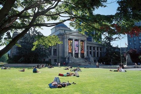 Many People Are Laying On The Grass In Front Of A Building With Columns