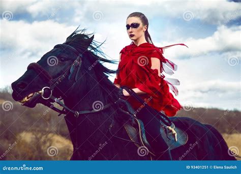 La Ragazza Guida Su Un Cavallo In Vestito Rosso Che Si Sviluppa Nel Campo Sul Cielo Immagine