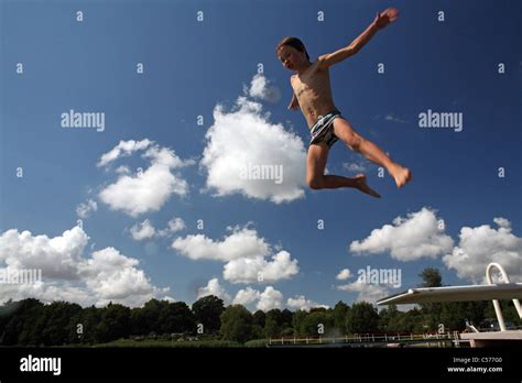 A Boy Jumping Into The Water From A Diving Board Stock Photo Alamy