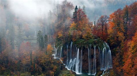Beautiful Waterfalls From Mountains Pouring On River Surrounded By