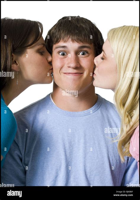 Boy Being Kissed On Both Cheeks By Two Girls Stock Photo Alamy