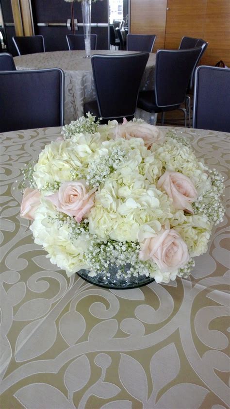 White and gold wedding cake. Pretty pink roses with white hydrangea and baby's breath ...