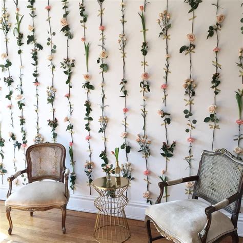 A Flower Wall With Fake Flowers With Exposed Tape Across The Stems