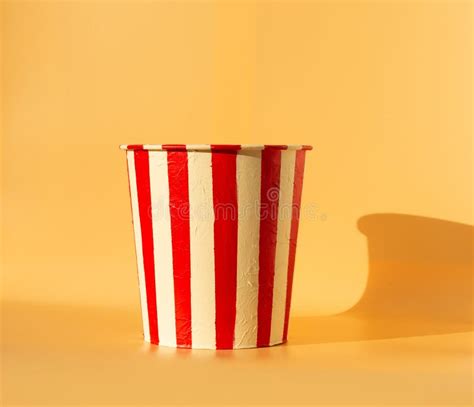 Empty Popcorn Bucket Surrounded By Spilled Popcorn On Yellow Background