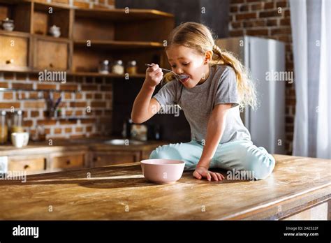 Little Cute Girl Eating Cereal In The Kitchen Stock Photo Alamy