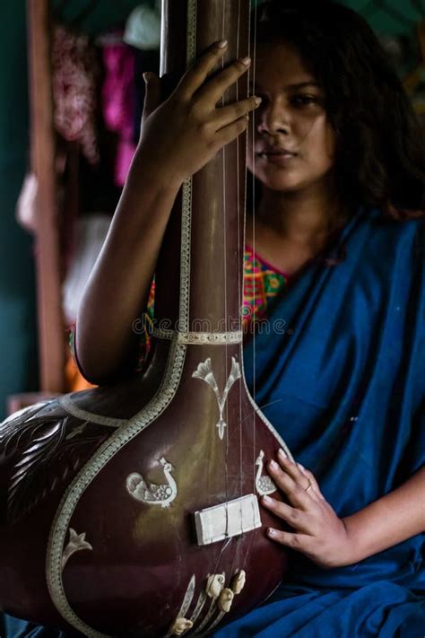 Middle Aged Indian Woman Holding An Indian Musical Instrument Tanpura