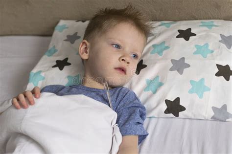 Sick Sad Child In Temperature And Headache Lies In Bed Flu Colds