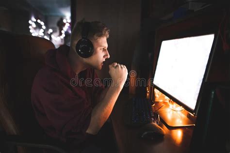 Focused Gamer Looks At The Computer Screen Watching The Game And