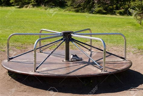 A Playground Merry Go Round In The Grass Stock Photo Picture And