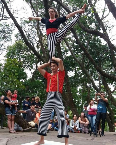 Two People Are Doing Acrobatic Tricks In Front Of A Group Of People