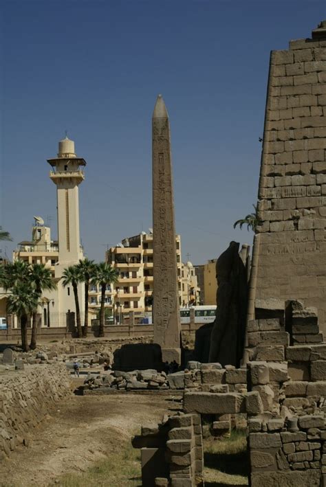 An Obelisk Within Luxor Temple With The Luxor Mosque In The Background