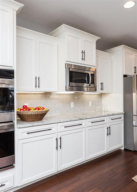 See how refreshing it is to decorate your shaker cabinets with simple hardware like the round white shaker kitchen cabinets paired with black kitchen island. This sophisticated, classic off-white kitchen features Belleair Maple Alabaster cabinets ...