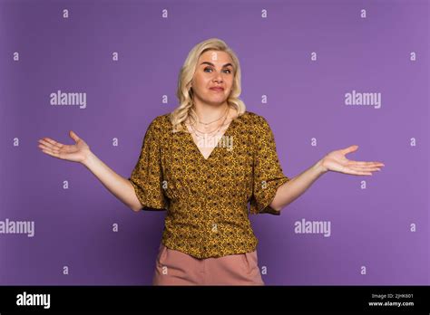 Confused Blonde Woman With Menopause Showing Shrug Gesture On Purple Stock Photo Alamy