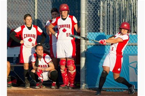 canada s women s softball team watches action from the dugout as teammate joey lye gets ready to