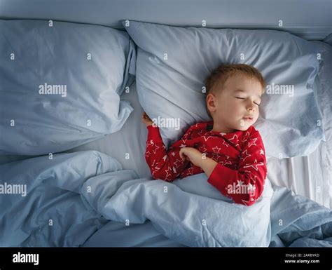 Sleepy Boy Lying In Bed With Blue Beddings Tired Child In Bedroom