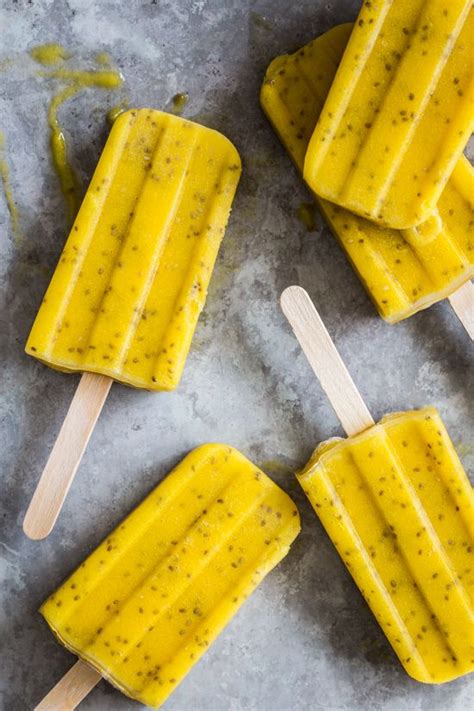 Four Popsicles With Lemon And Poppy Seeds On Them Sitting On Top Of A Table