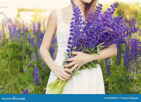 Schöne Sexy Frau In Den Weißen Sundress Mit Einem Blumenstrauß In Den Händen Von Lupine Auf Dem