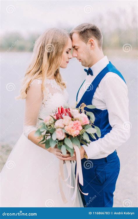 Sensitive Side Portrait Of The Newlyweds Standing Head To Head With The