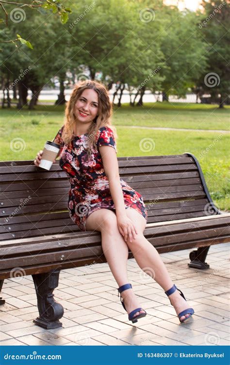 Portrait Of A Smiling Girl Sitting On A Bench With Coffee Stylish Happy Young Woman In A Bright