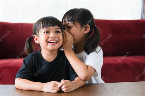 Premium Photo Happy Little Asian Siblings Sharing Secrets