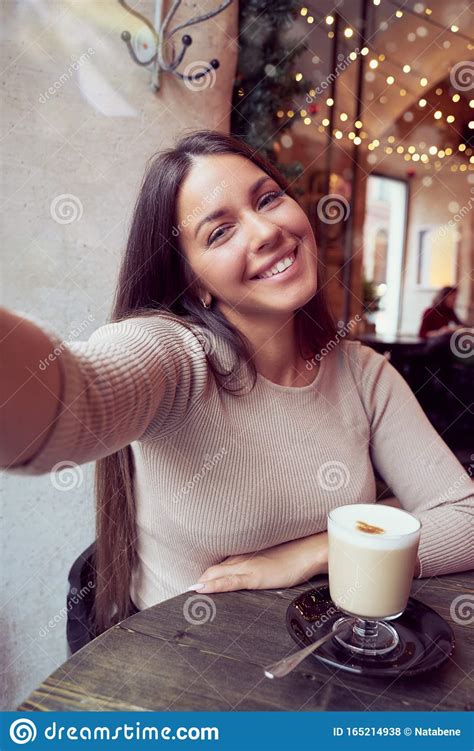 Beautiful Happy Girl Taking A Selfie In Cafe During Christmas Holidays Smiling And Looking At