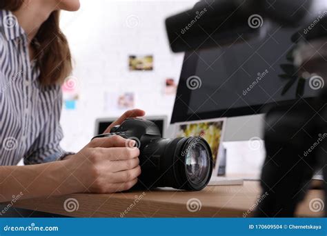 Professional Photographer With Camera Working At Table In Office Stock