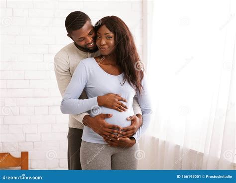 African Husband Embracing His Pregnant Wife At Home Stock Image Image