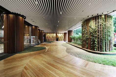 The Inside Of A Building With Wood Flooring And Green Plants On The
