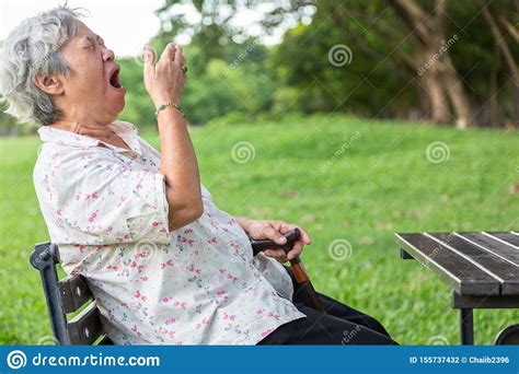 Asian Senior Woman Has Sleepy Expressionelderly Woman Yawning Covering Open Mouth With Handold