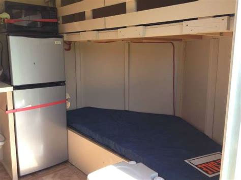 There Is A Bunk Bed With A Mattress On The Bottom And A Refrigerator In