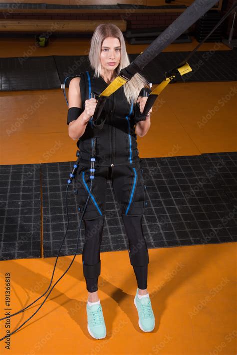 Beautiful Woman In Electrical Muscular Stimulation Suit Doing Squat